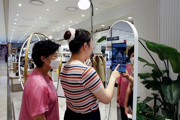 A woman shops using AR make up at a cosmetic shop in a department store in Seoul, South Korea, July 2, 2020. Picture taken July 2, 2020. REUTERS/Heo Ran